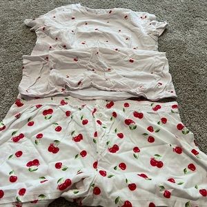Pink sleep shirt and shorts both have cherrys on them